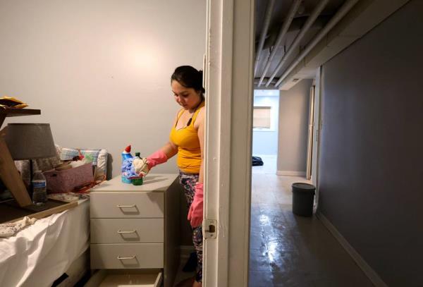 Patricia Medina cleans her flood-damaged apartment along the 1900 block of South 51st Court in Cicero on July 3, 2023.