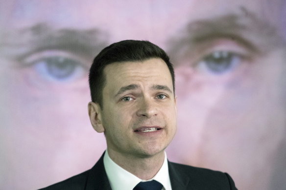 Russian opposition activist Ilya Yashin in front of a poster of Vladimir Putin, the man who sent him to prison.