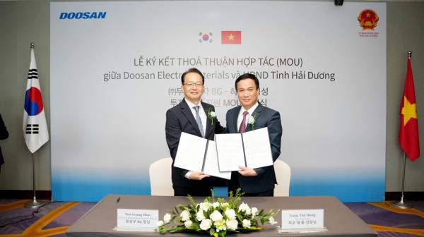 Yoo Seung-woo (left), president of Doosan Corp. Electro-Materials, poses for a photo with Trieu The Hung, chairman of the Hai Duong Provincial People's Committee, after signing a memorandum of understanding in Hanoi, Vietnam, Friday. (Doosan)