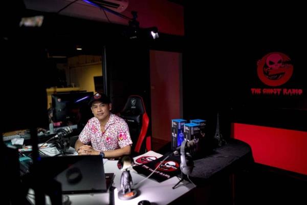Ghost Radio station host Jack Watcharaphon poses in his studio in Bangkok. - It is almost midnight, and above a semi-abando<em></em>ned Bangkok shopping centre, Ghost Radio is on air. Rapid-fire comments ping across the studio's screens as thousands tune in o<em></em>nline to hear callers describe their encounters with Thailand's supernatural. - Pic: AFP